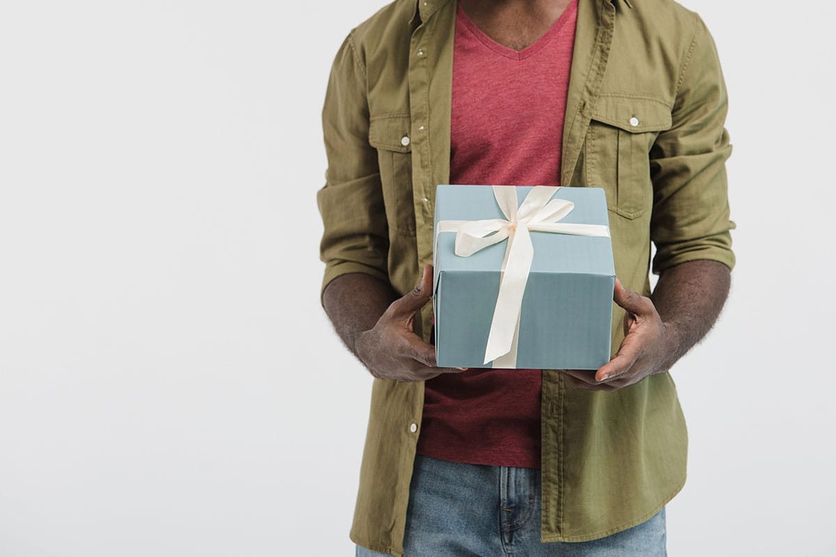Man holding a gift box from San Antonio custom merchandise.